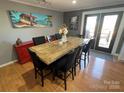 A dining room with a large table and black chairs, a red buffet and a view outside at 132 Marina Ln, Mooresville, NC 28117