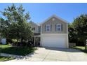 Two-story home featuring a large two-car garage and manicured landscaping at 14413 Lake Crossing Dr, Charlotte, NC 28278