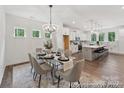 Open-concept dining area featuring a glass table, stylish chairs, and a modern chandelier at 148 Tangle River Dr # 67, Statesville, NC 28677
