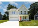 Charming two-story home with a light gray exterior, a red front door, and an attached garage at 1645 Carolina Cir, Gastonia, NC 28054