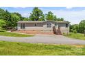 Cozy single-story home with a well-maintained yard, complemented by a wooden deck and charming landscaping at 1730 Woodbend Ln, Conover, NC 28613