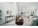 Bright living room featuring neutral tones, a vaulted ceiling, and an open concept design to the kitchen and dining room at 2116A Glenwood St, Kannapolis, NC 28083