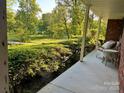 Inviting porch with a wicker chair and view of the well-maintained landscaping and natural surroundings at 2130 Vashti Rd, Taylorsville, NC 28681