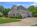 Side view of a beautiful two-story home with a three-car garage and well-maintained landscaping at 224 Hidden Meadows Dr, Mooresville, NC 28117