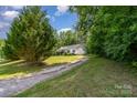 A serene setting of a cozy home tucked away among towering trees and lush greenery at 321 Woodcrest Dr, York, SC 29745