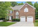 Charming brick home featuring a two-car garage, manicured lawn, and an inviting entryway at 405 Deer Brush Ln, Waxhaw, NC 28173