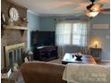 Bright living room with a cozy fireplace, ceiling fan, and natural light at 4337 Gelinda Ct, Gastonia, NC 28056