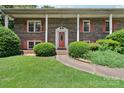 Up close view of the home's front entrance and door, framed by brick and shrubbery at 5626 Sandhurst Rd, Hickory, NC 28602