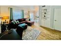 Inviting living room featuring hardwood floors, a leather sectional, built in shelving, and lots of natural light at 5947 Quail Hollow Rd # A, Charlotte, NC 28210