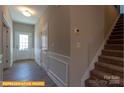 Hallway with staircase, featuring a light-colored wall, white trim, and wood-look flooring at 6328 Busch Way, Midland, NC 28107
