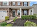 Close-up of a home's welcoming front porch with stone accents, manicured landscaping, and covered entry at 7339 Millstone Sw Cir, Concord, NC 28025