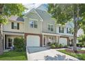 Two-story townhouse with a one-car garage, lush landscaping, and a welcoming front porch at 8108 Christmas Ct, Charlotte, NC 28216