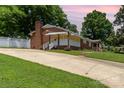 Exterior view of the brick home with a long driveway and well-maintained landscaping at 839 Montford Dr, Charlotte, NC 28209