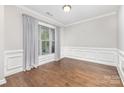 Bright dining room with hardwood floors, decorative molding, and large window with draperies at 8709 Raven Top Dr, Mint Hill, NC 28227