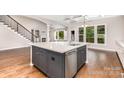 Modern kitchen featuring a large island with a sink, stainless steel appliances, and hardwood flooring at 8709 Raven Top Dr, Mint Hill, NC 28227