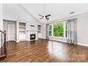Spacious living room with fireplace, built-in shelving, high ceilings, and lots of natural light at 8709 Raven Top Dr, Mint Hill, NC 28227