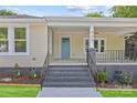Charming front porch featuring stylish steps, black railing, and a vibrant blue front door at 933 Old Charlotte Rd, Concord, NC 28027