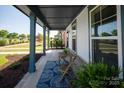 Inviting front porch with seating area on a patterned rug, perfect for relaxing outdoors at 1036 Riverwalk Pkwy, Rock Hill, SC 29730