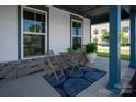 Cozy front porch seating area with a table and chairs on a stylish blue patterned rug at 1036 Riverwalk Pkwy, Rock Hill, SC 29730