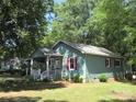 Charming home featuring a covered porch, colorful shutters, and lush lawn at 1051 S Brady Ave, Newton, NC 28658