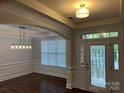 Elegant foyer features hardwood floors, wainscoting, and a decorative chandelier above the dining area at 10715 Tom Short Rd, Charlotte, NC 28277