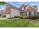 Lovely two-story home featuring a mix of brick and siding, complemented by lush landscaping at 108 Planters Dr, Statesville, NC 28677