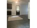 Open concept kitchen with updated cabinets, white appliances, and a large area rug at 120 Booker St, Wingate, NC 28112