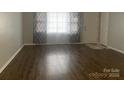 Living room featuring new hardwood floors, modern gray curtains, and a neutral color scheme at 120 Booker St, Wingate, NC 28112