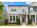Close up exterior shot of a gray two-story townhome featuring stone accents and a manicured lawn at 1201 Township Pkwy, Belmont, NC 28012