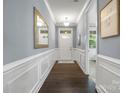 Inviting hallway features elegant molding, dark wood floors, a mirror, and a view of the front door at 1284 Independence St, Fort Mill, SC 29708