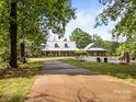 Picturesque home with a metal roof and wraparound porch, nestled within a large yard with mature trees and a pool at 1433 Kern Carlton Rd, Salisbury, NC 28146
