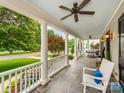 Spacious front porch with slate tile, white columns, ceiling fans, and seating for relaxing outdoors at 1600 Princeton Ave, Charlotte, NC 28209