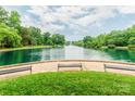 Scenic view of a peaceful pond featuring a fountain, surrounded by lush trees and manicured green grass at 1600 Princeton Ave, Charlotte, NC 28209