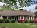 Inviting red brick house with a well-maintained lawn, manicured shrubs, and colorful flowering bushes at 1614 Statesville Blvd, Salisbury, NC 28144