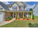 Charming house exterior featuring a cozy front porch and colorful flower beds at 166 Glenn Allen Rd, Mooresville, NC 28115