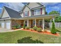 Lovely exterior showcases stone accents, a welcoming porch, and colorful landscaping details at 166 Glenn Allen Rd, Mooresville, NC 28115