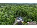 Aerial view of a home surrounded by lush trees and greenery, showcasing the expansive property at 1730 Eden Glen Dr, Dallas, NC 28034