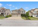 Inviting two-story home displays manicured lawn, stone accents, and double garage, set under a partly cloudy sky at 1810 Kerwick Ct, Lancaster, SC 29720