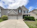 Attractive two-story home features a stone facade, double garage, manicured lawn and front shrubbery at 1810 Kerwick Ct, Lancaster, SC 29720