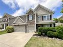Charming two-story home with stone accents and a three-car garage, complemented by a well-manicured lawn and landscaping at 1810 Kerwick Ct, Lancaster, SC 29720