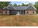 An inviting single-story home featuring a stone and gray facade with an unfinished front lawn at 209 Stafford Estates Dr, Salisbury, NC 28146