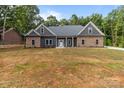 An inviting single-story home featuring a stone and gray facade with an unfinished front lawn at 209 Stafford Estates Dr, Salisbury, NC 28146