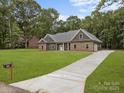 Charming single-story home featuring a well-manicured lawn and inviting stone and siding exterior at 209 Stafford Estates Dr, Salisbury, NC 28146