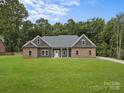 Charming single-story home featuring a well-manicured lawn and inviting stone and siding exterior at 209 Stafford Estates Dr, Salisbury, NC 28146
