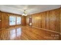 Spacious living room featuring beautiful hardwood floors, natural light, and a vintage ceiling fan at 220 Parker Ave, Mooresville, NC 28115
