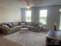 Inviting living room with plush sectional sofa, area rug, and ample natural light at 2411 Bonterra Blvd, Indian Trail, NC 28079