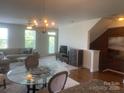 Open living room with chandelier, hardwood floors, and comfortable seating arrangement at 2411 Bonterra Blvd, Indian Trail, NC 28079