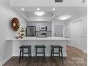 Modern kitchen features stainless appliances, breakfast bar with seating, and grey shaker cabinets at 300 W Fifth St # 509, Charlotte, NC 28202