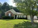 Inviting single-story home with brick details, well-kept landscaping, and an attached two-car garage at 3124 Burkston Rd, Charlotte, NC 28269