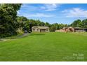 Sprawling front lawn showcasing a charming home nestled among mature trees at 3125 Leonard Dr, Gastonia, NC 28056